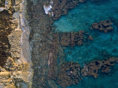 Denizde kayaların havadan görünüşü. Yukarıdan görünen deniz tabanının genel görünümü, şeffaf su. Deniz yatağı. Pizzo Calabro, Calabria, İtalya