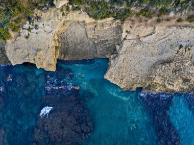 Denizde kayaların havadan görünüşü. Yukarıdan görünen deniz tabanının genel görünümü, şeffaf su. Deniz yatağı. Pizzo Calabro, Calabria, İtalya