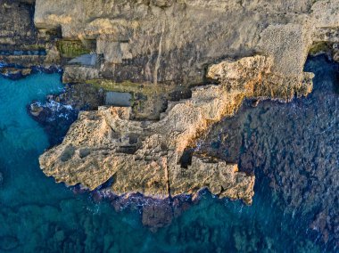Denizde kayaların havadan görünüşü. Yukarıdan görünen deniz tabanının genel görünümü, şeffaf su. Deniz yatağı. Pizzo Calabro, Calabria, İtalya