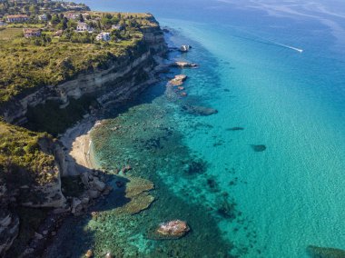 Calabrian sahilinin hava manzarası, kristal berrak deniz ve lüks villalara bakan kayalıklar. Tropea 'nın güneyindeki Riaci bölgesi. Calabria. İtalya
