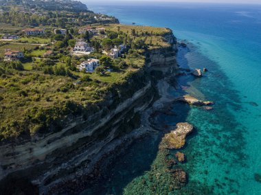 Calabrian sahilinin hava manzarası, kristal berrak deniz ve lüks villalara bakan kayalıklar. Tropea 'nın güneyindeki Riaci bölgesi. Calabria. İtalya