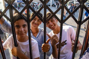 İstanbul, Türkiye, Ortadoğu: Taksim Meydanı 'ndan gelen tarihi T2 Hattı Taksim-Tünel tramvayında asılan bir Türk çocuk, şehrin en ünlü caddelerinden biri olan İstiklal Caddesi' nin raylarında asılı duruyor.