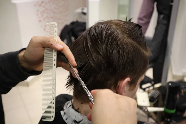 主美发师做发型和风格与剪刀和梳子 主人在理发店里堆叠男人的头发 理发师为年轻人做发型 理发店 — 图库照片