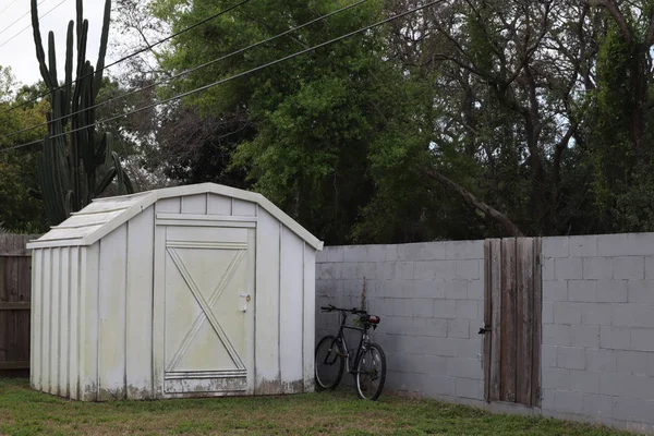 white backyard shed. bicycle at the fence