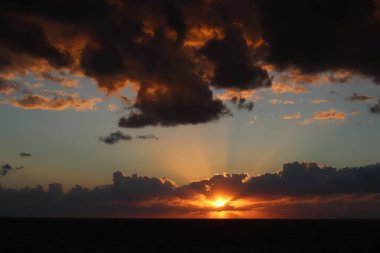 Meksika körfezinde güzel gün batımı. okyanus üzerinde güzel turuncu altın gün batımı. güneş, denizdeki bulutların arasından batan.