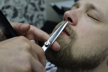 Mükemmel şekil leniyorum. Makas ve tarak ile yakın çekim yan görünüm. Master Barber saç modeli ve stil yok, Sakallı Adam Berber tarafından acımasız gay için Sakal Saç Kesimi başlar. Berber dükkanı.