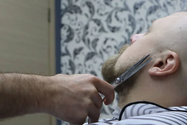 获得完美的形状 用剪刀和梳子特写侧视图 大师巴伯做发型和造型 胡子男子获得胡子理发由理发师为残酷的同性恋 理发店 — 图库照片