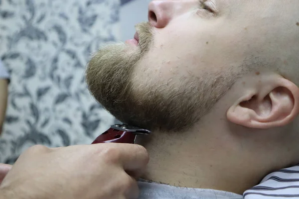 理发师在椅子理发店上剪下客户男子的胡须 胡子理发理发师剃胡子与电动剃须刀在老式理发店 修剪的详细信息 理发修剪胡须的特写 — 图库照片
