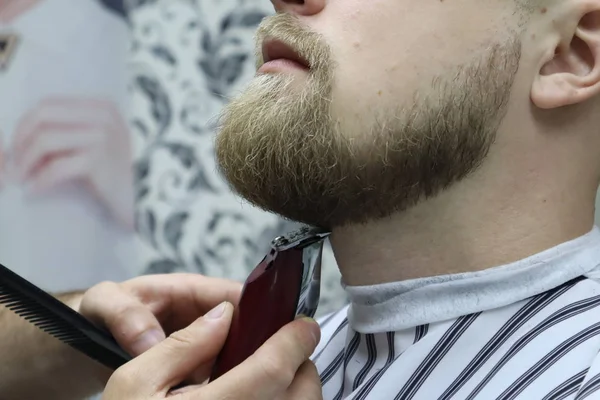 理发师在椅子理发店上剪下客户男子的胡须 胡子理发理发师剃胡子与电动剃须刀在老式理发店 修剪的详细信息 理发修剪胡须的特写 — 图库照片