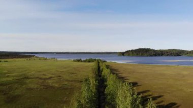 Kırsal yol. rezervuar üst görünümünde yeşil orman ve su arasında yol. yeşil orman üzerinden görünüm yolu. 4k görüntüleri Toksovo, Malinovaya Gora.