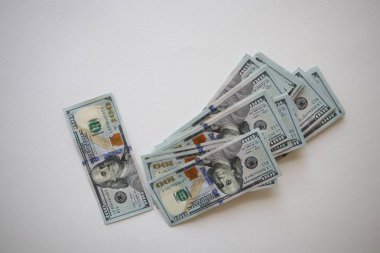 Beyaz arka planda 100 dolarlık banknotlar. Yeni yüz dolarlık banknotlar yığını.