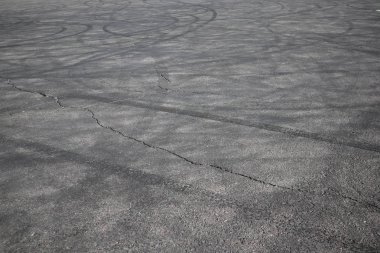 lastik izleri. asfalt yolda tekerlek izi. araba tekerlekleri izleri ile asfalt. Çimento üzerindeki lastik lastiklerden kaynaklanan frenleme izleri. Lastik izleri ile soyut yol arka plan. sibur arena