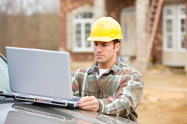 Construção: Trabalhador usa computador sem fio — Fotografia de Stock