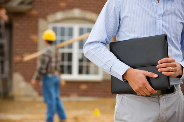 Construção: Agente Segurando Portfólio com Trabalhador em Fundo — Fotografia de Stock