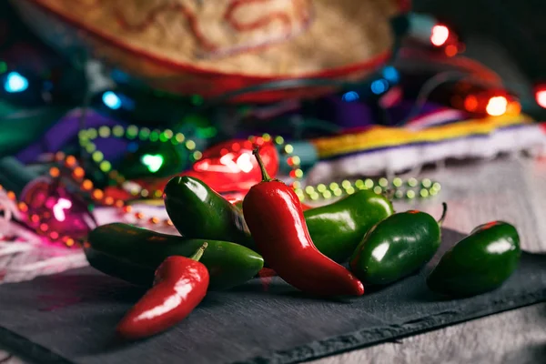 Fiesta: Hot Peppers na pokładzie łupków z dekoracjami party — Zdjęcie stockowe