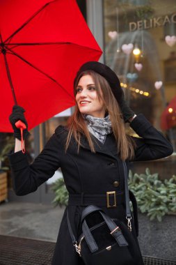 Bir kafede şehrin önünde kırmızı şemsiye ile güzel bir kadın portresi