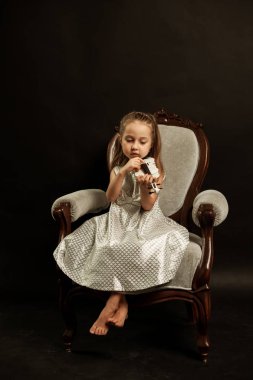 Küçük kemancı, beyaz keman, güzel fotoğraf, karanlık bir arka plan üzerinde.