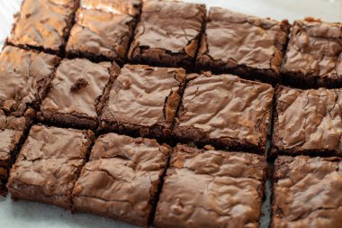 Çikolatalı kek dilimlenmiş ve bir kağıt ile bir tepsi üzerinde ışık karışık 