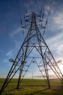 Elektrik direkleri ararken bakış açısı mavi gökyüzü ve yeşil alan ile kapatmak