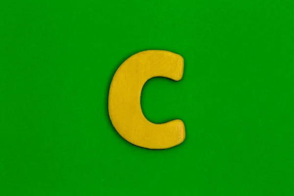 Γράμμα c κατασκευασμένο από ξύλο βαμμένο πορτοκαλί χρώμα σε πράσινο φόντο — Φωτογραφία Αρχείου