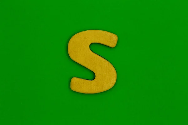 Letter s made of wood painted orange on green background — Stock Photo, Image