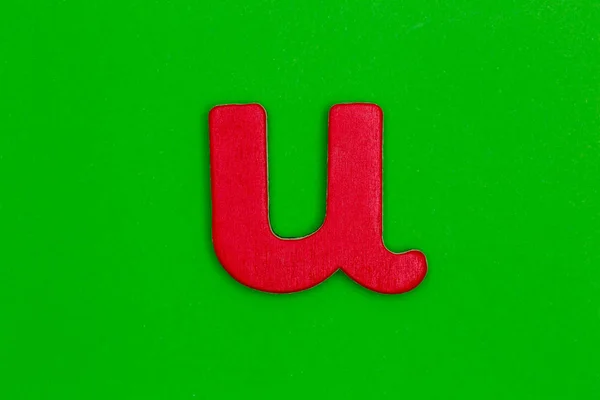 Letra u hecha de madera pintada de rojo sobre fondo verde — Foto de Stock