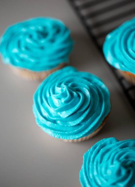 Gri bir tezgah üzerine mavi krema ile cupcakes