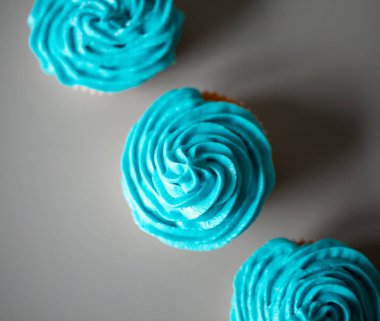 Gri bir tezgah üzerine mavi krema ile cupcakes