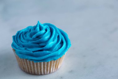 Cupcake beyaz mermer tezgah üzerine mavi krema ile