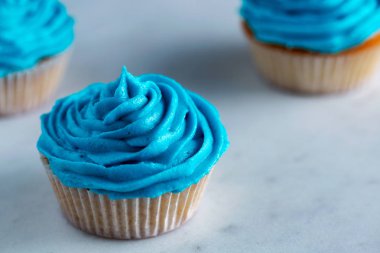 Beyaz mermer tezgah üzerine mavi krema ile cupcakes