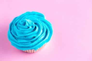 Pembe bir tezgah üzerine mavi krema ile cupcake