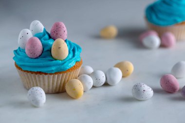Mavi şeker buzlanma ile cupcakes Paskalya yumurta üzerinde beyaz bir marbl