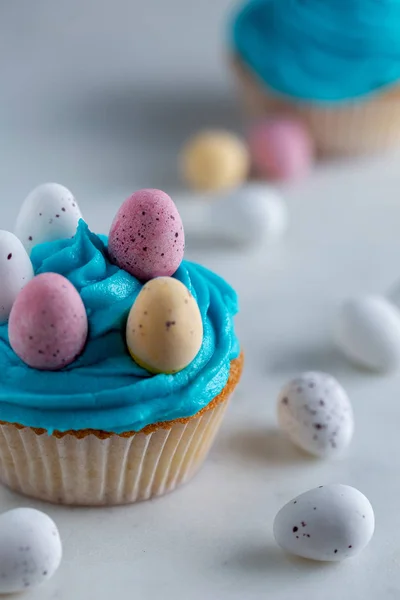 Cupcakes mit blauem Zuckerguss und Ostereiern auf weißem Marmor — Stockfoto