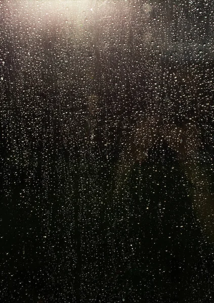 Gouttes de pluie sur fenêtre en verre avec soleil qui brille à travers — Photo
