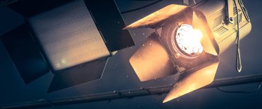 Tavanda asılı profesyonel turuncu stüdyo spot. Işıklı toz parçacıkları ve objektif mercek parlamaları. 