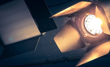 Tavanda asılı profesyonel turuncu stüdyo spot. Işıklı toz parçacıkları ve objektif mercek parlamaları. 