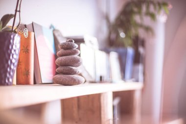 Feng Shui: Taş cairn ön planda, arka plan bulanık oturma odasında. Denge ve gevşeme.