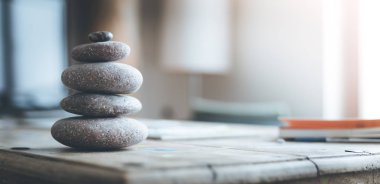 Feng Shui: Taş cairn ön planda, arka plan bulanık oturma odasında. Denge ve gevşeme.