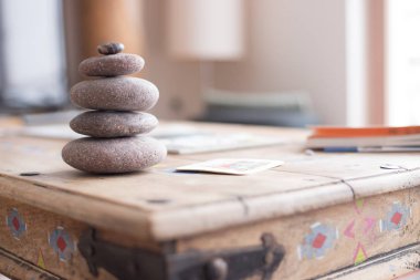 Feng Shui: Taş cairn ön planda, arka plan bulanık oturma odasında. Denge ve gevşeme.