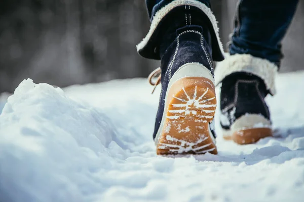 穿蓝色牛仔裤的女孩在冬天徒步旅行 腿和鞋子 — 图库照片