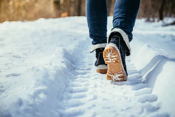 穿蓝色牛仔裤的女孩在冬天徒步旅行 腿和鞋子 — 图库照片