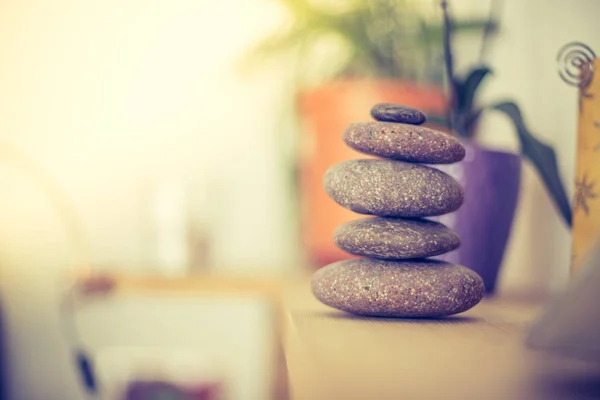 Feng Shui: Taş cairn ön planda, arka plan bulanık oturma odasında. Denge ve gevşeme.
