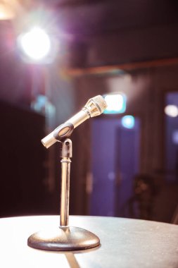 Stüdyo, stüdyo ışıkları bulanık arka planda metal mikrofon