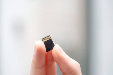 Genç adam elinde küçük bir hafıza kartı tutuyor, mesaj alanı.