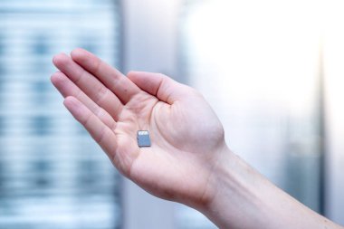 Genç adam elinde küçük bir hafıza kartı tutuyor, mesaj alanı.