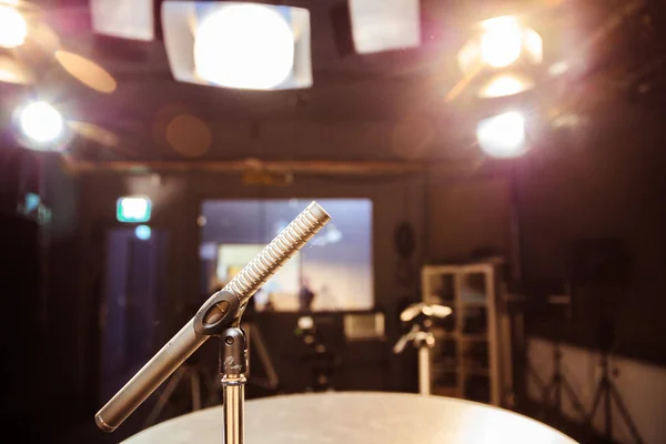 Metal microphone in the studio, studio lights in the blurry background