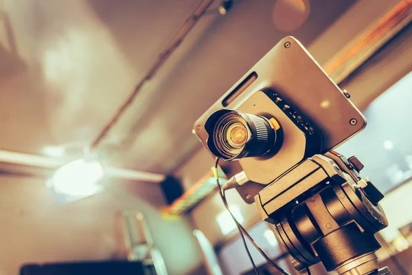 Film camera on a tripod in a television broadcasting studio, spotlights and equipment