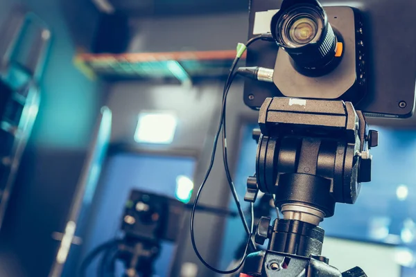 Film camera on a tripod in a television broadcasting studio, spotlights and equipment