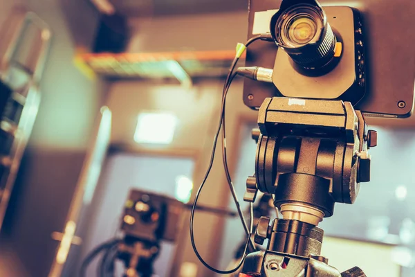 Film camera on a tripod in a television broadcasting studio, spotlights and equipment