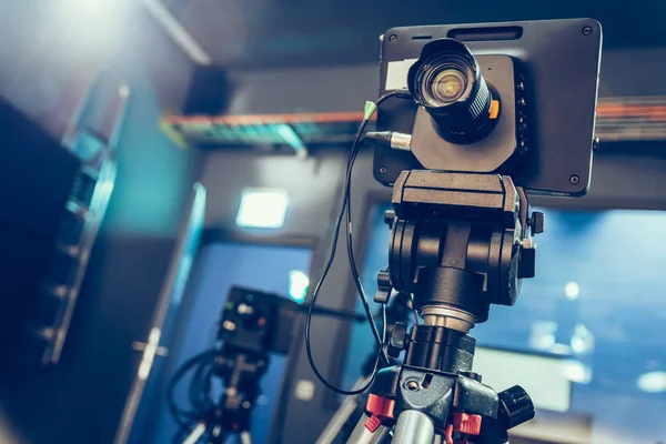 Film camera on a tripod in a television broadcasting studio, spotlights and equipment